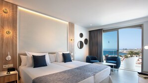 A modern hotel room with a large bed, a desk, a chair, and a view of the sea. - Hotel Guayarmina Princess - Adults Only (+16) (Adeje)