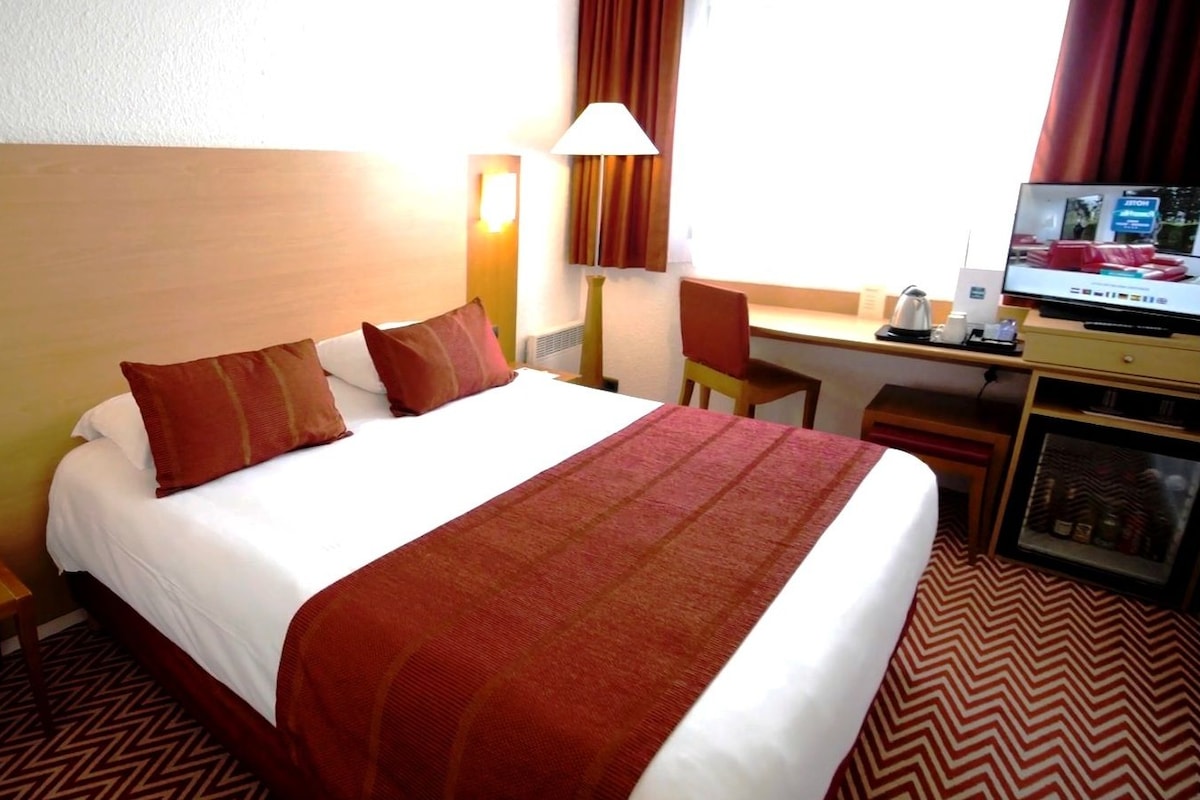 Luxe beddengoed, een minibar, een bureau, een laptopwerkplek
