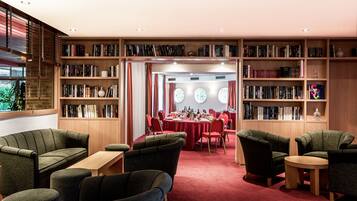 Een bibliotheek met boekenkasten, een eetgedeelte en zitplaatsen.