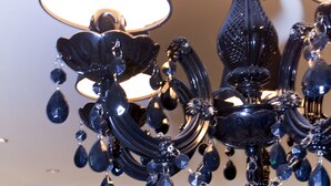 Een kroonluchter met meerdere lagen en hangende decoraties in een hotel.