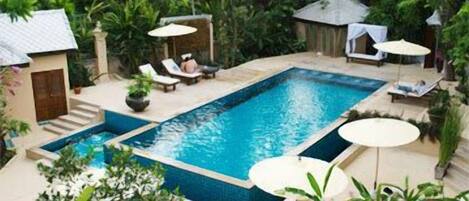 Una piscina al aire libre, tumbonas