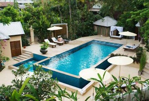 Una piscina al aire libre, sillones reclinables de piscina