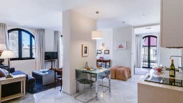 Departamento Deluxe, 1 habitación | Área de sala de estar | Televisión de pantalla plana