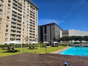 Ein Hotel mit Schwimmbad, Außenbereich und einem modernen Gebäude.