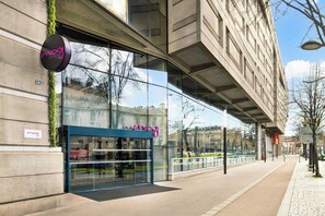 A modern building with a glass facade, a visible entrance, and a sign reading 'mozy.'