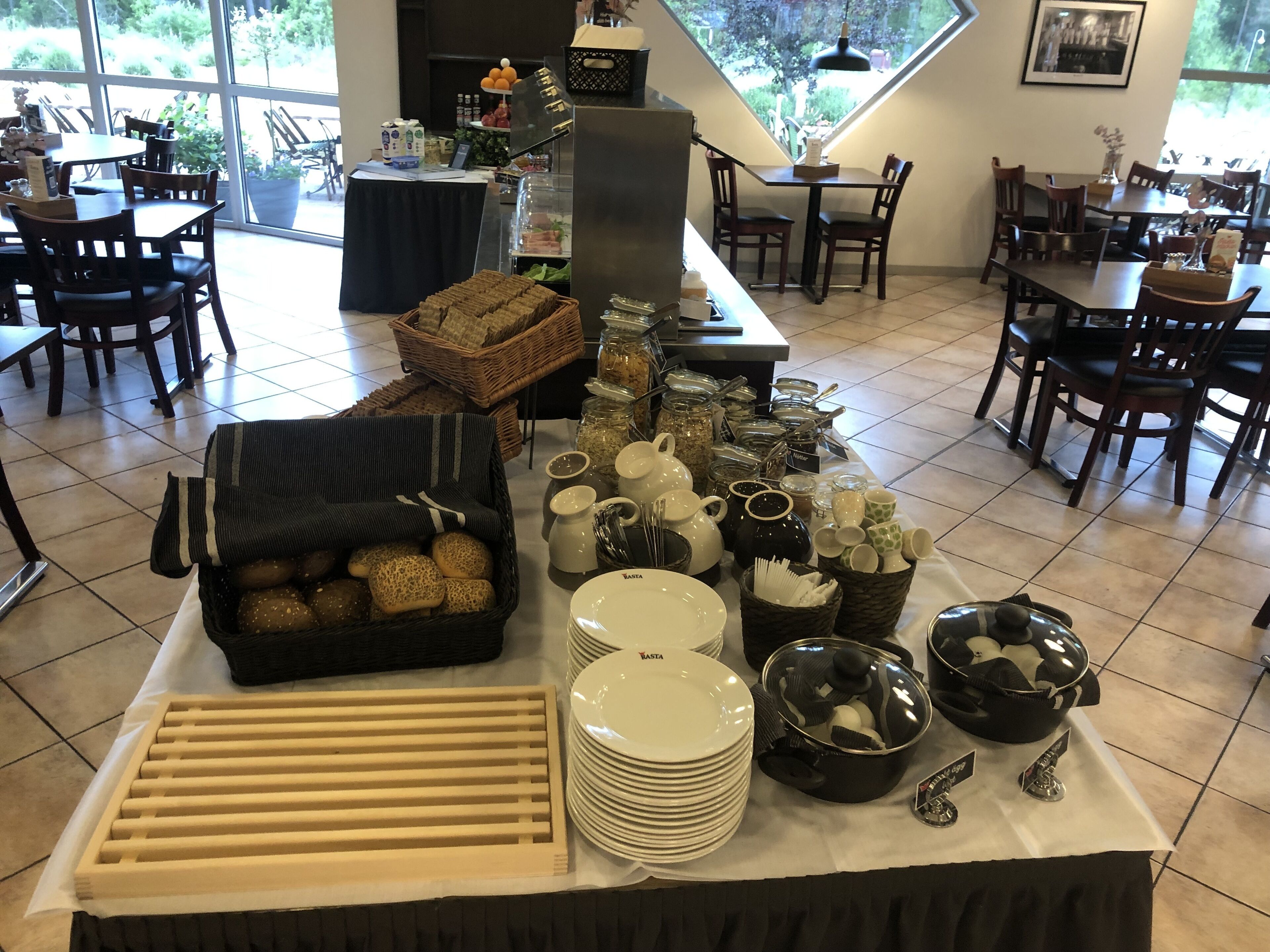 A buffet setup with various food items, utensils, and dishes.