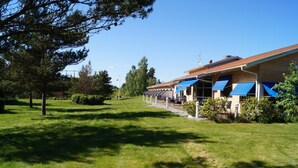 A building with a row of rooms, each with a blue awning.