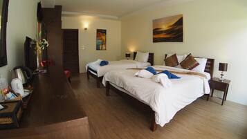 A hotel room with two beds, a wooden desk, a coffee maker, and a painting on the wall.