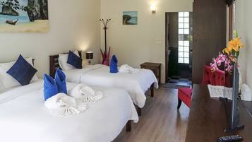 A hotel room with two beds, a desk, a chair, a lamp, and a painting on the wall.