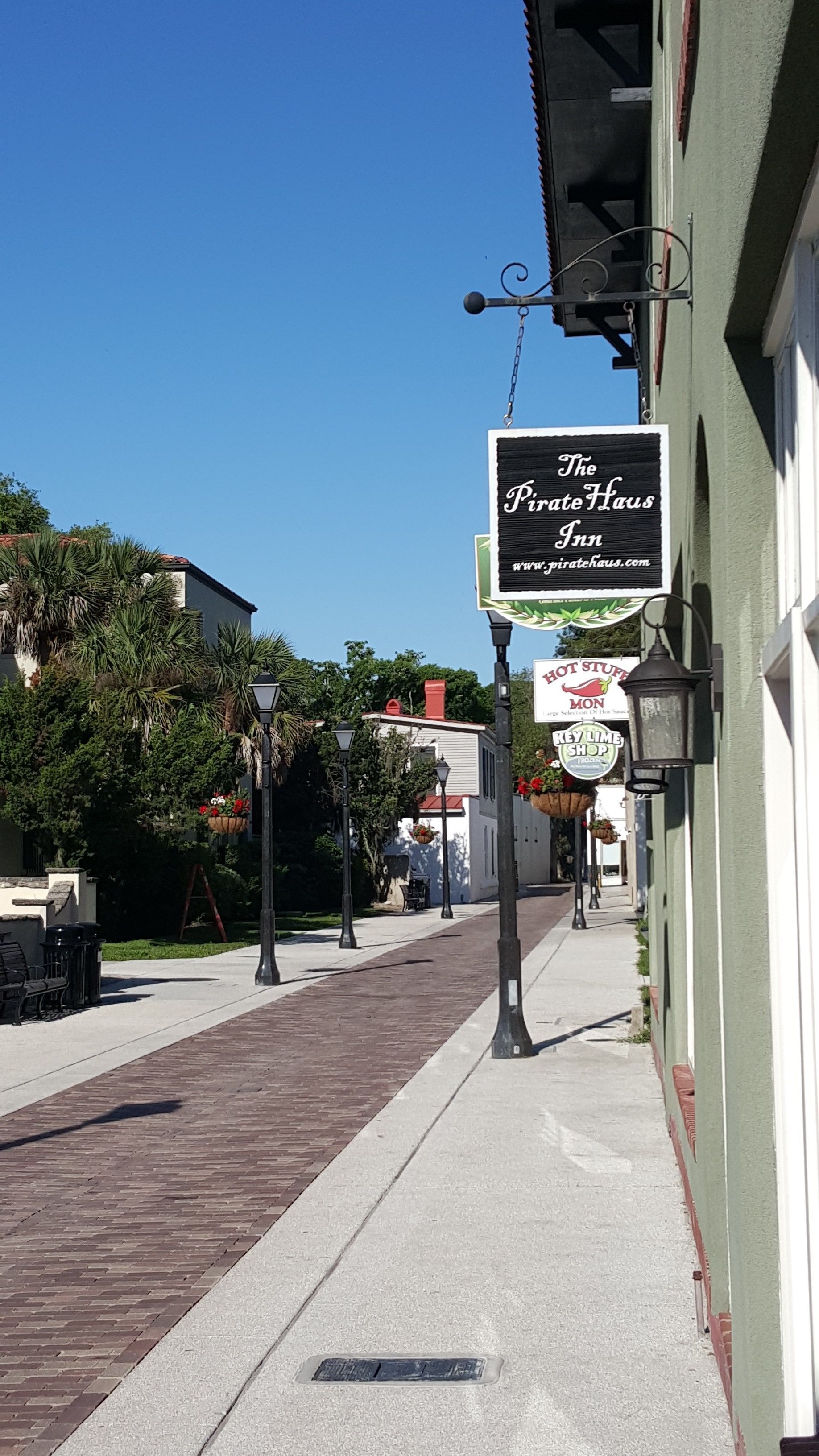 A street view with a building labeled 'The Pirate Haus Inn' and a sign for 'HOT STUFF MONKEY'.