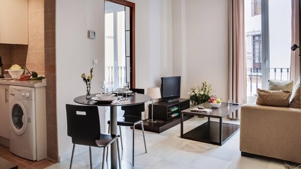 Una sala de estar moderna con comedor, lavadora y balcón con vistas.