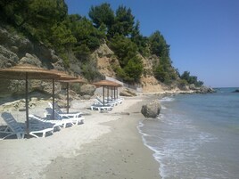 Una playa cerca, sillas reclinables de playa, sombrillas