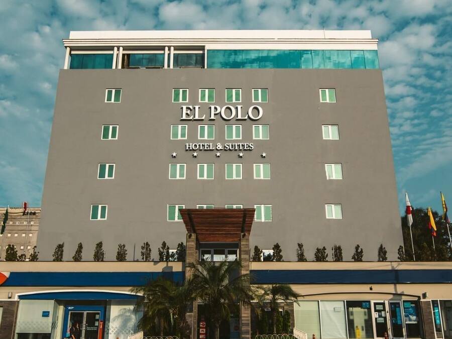 Het uiterlijk van El Polo Hotel & Suites, met een moderne gevel, een opvallende ingang, meerdere ramen en een heldere lucht.