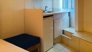 A compact kitchen with a microwave, sink, and a small dining area. - Hotel H Américas Guadalajara (Guadalajara)
