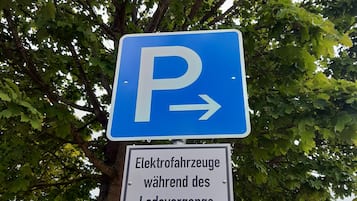 Un panneau de signalisation indiquant un espace de stationnement, avec une flèche directionnelle et un texte en allemand en dessous.