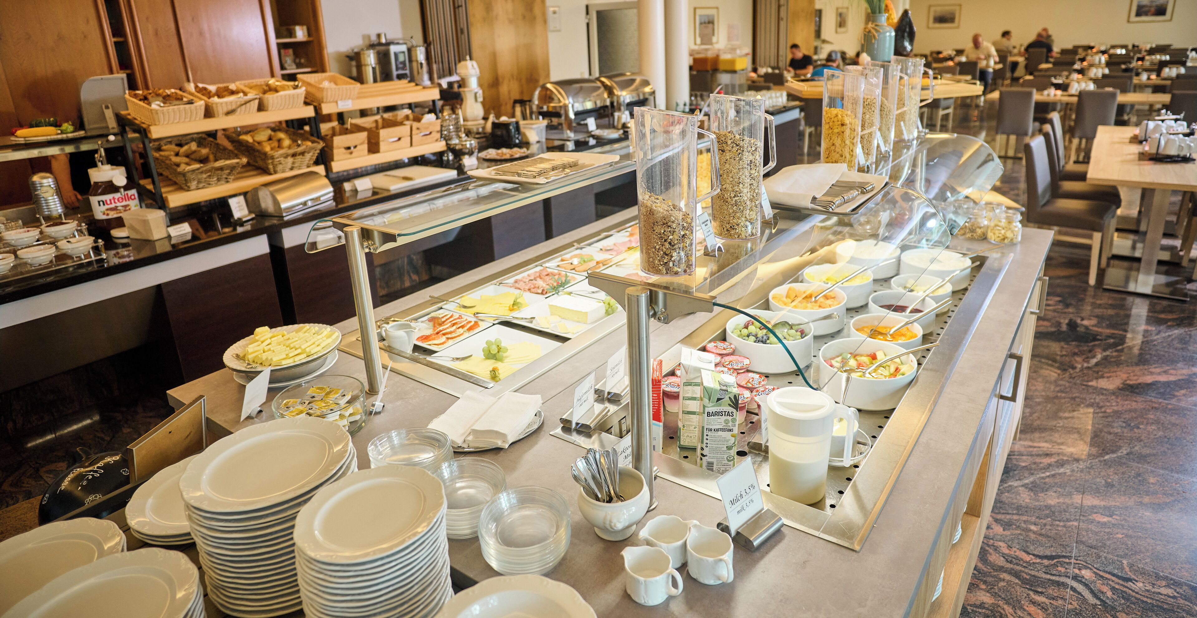 A buffet setup with various food items and utensils.