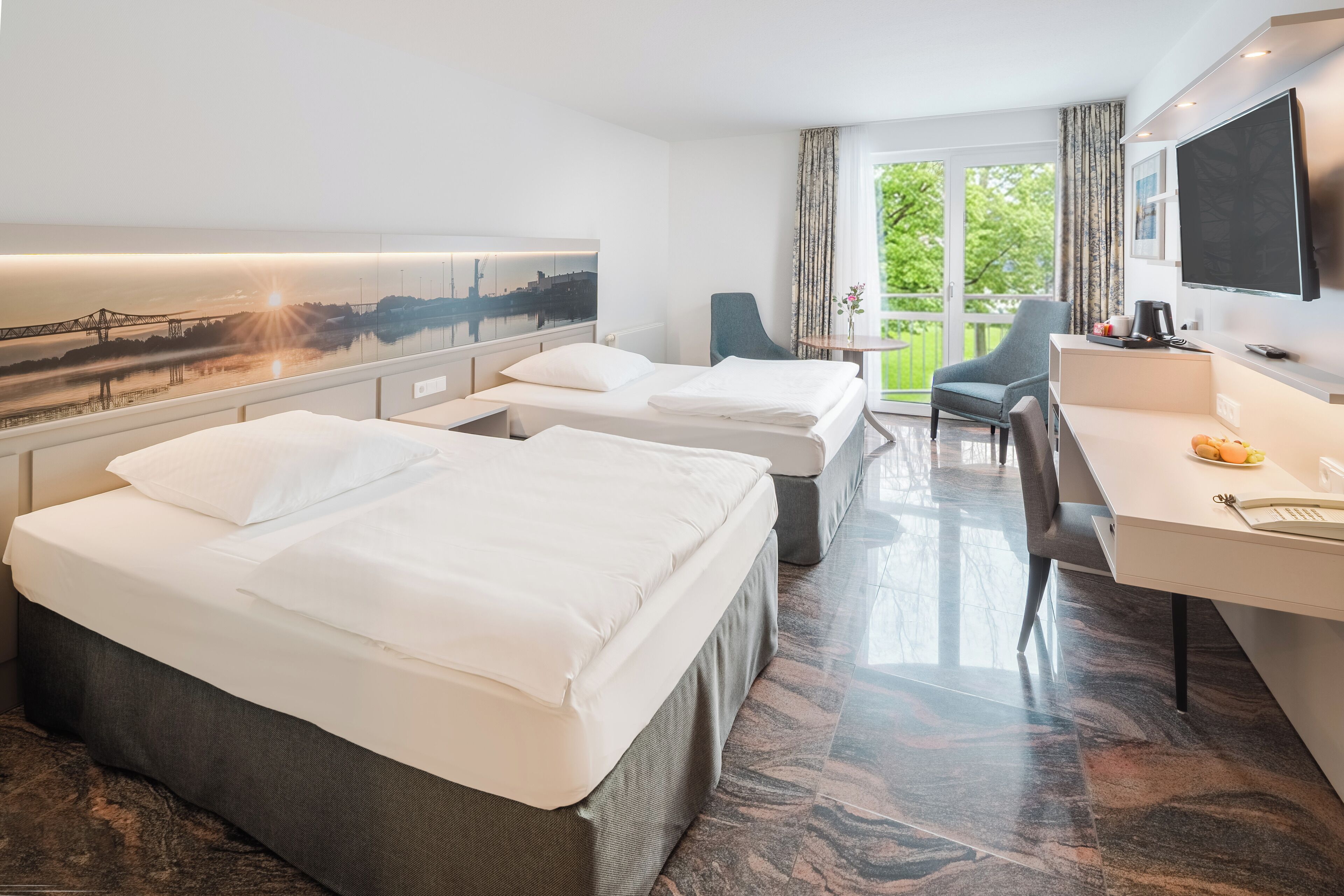 A hotel room with two beds, a desk, a chair, a TV, and a cityscape view.