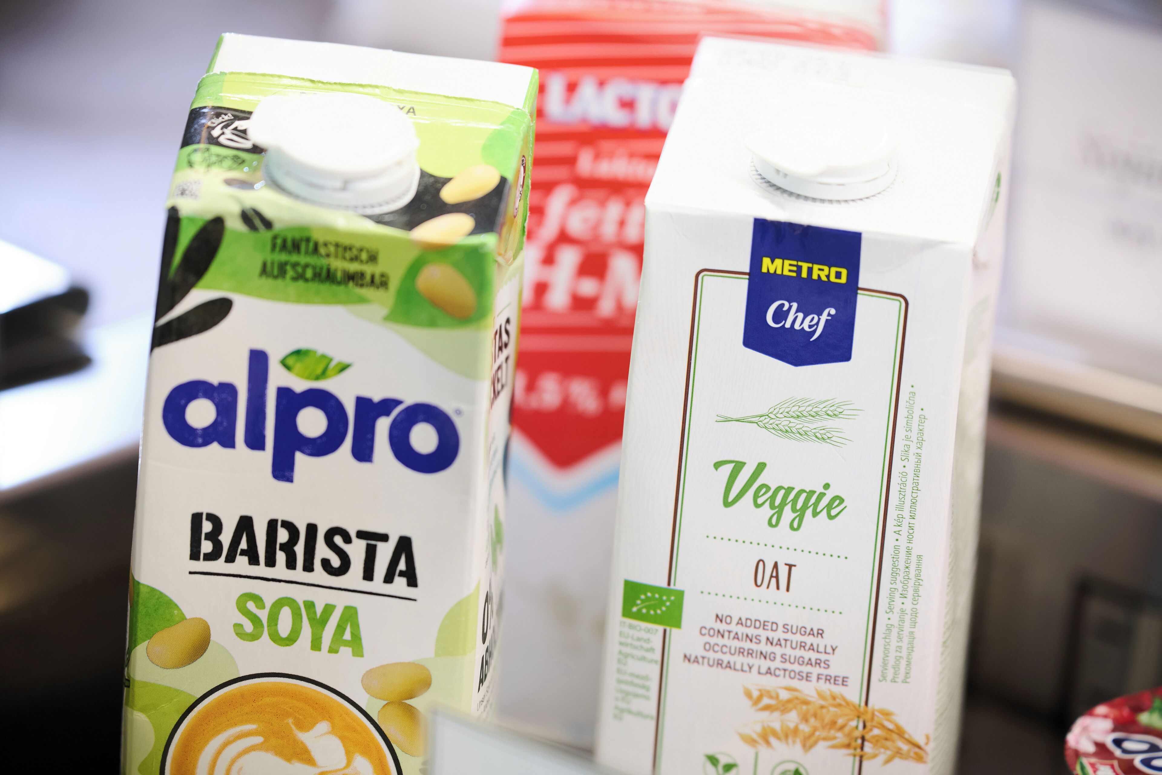 Dos cartones de leche, uno etiquetado como 'alpro BARISTA SOYA' y el otro 'METRO Chef Veggie OAT'.