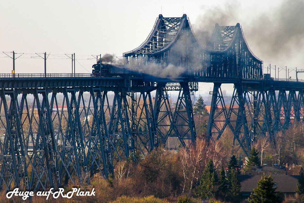 A large steel bridge with smoke rising from it.