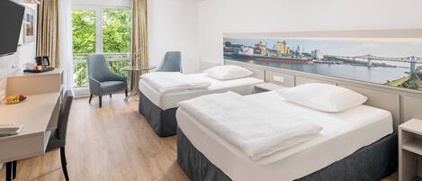 A hotel room with two beds, a desk, a chair, and a large window with a cityscape view.
