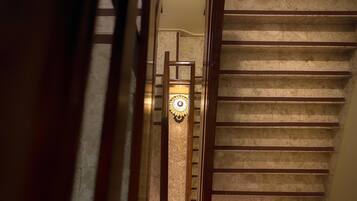 A staircase with a wooden handrail and a glass balustrade.