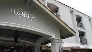 Das äußere Erscheinungsbild der Plaza Florida Suites zeigt eine moderne Fassade mit einer gut sichtbaren Beschilderung, Balkonen und einem klaren architektonischen Design.