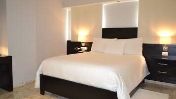 Een moderne hotelkamer met een groot bed, twee nachtkastjes met lampen, en een hoofdbord met geïntegreerde verlichting.