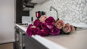 A kitchen with a modern design, featuring a stone backsplash and stainless steel appliances. - The Queen Luxury Apartments - Villa Fiorita (Luxembourg City)