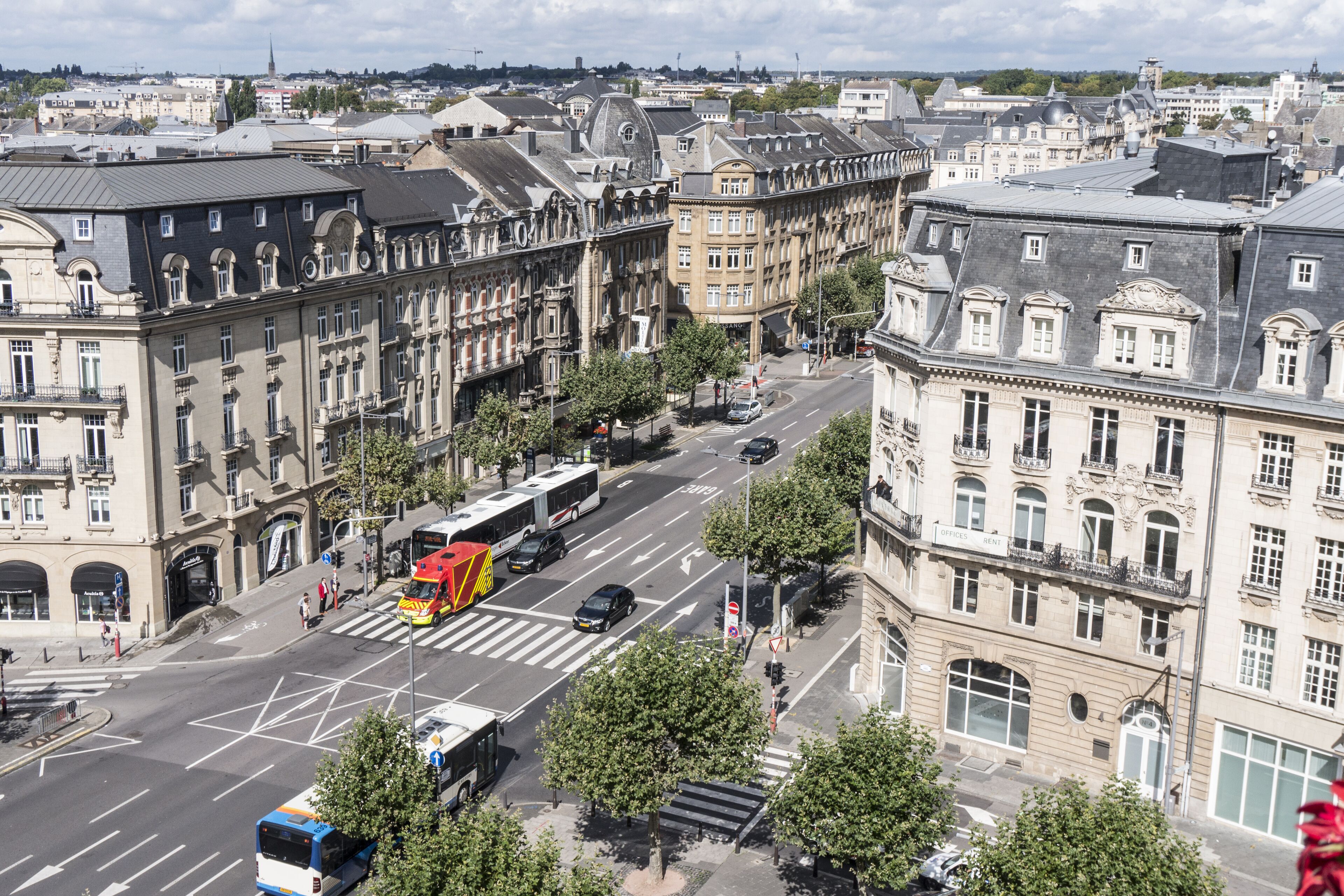 Una strada cittadina con edifici storici, un tram e un attraversamento pedonale.