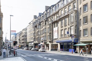 A street view with buildings, cars, and pedestrians.