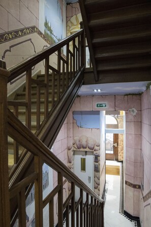 A staircase with a wooden handrail leading to an upper floor.