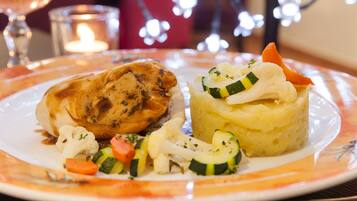 A plate with a piece of meat, mashed potatoes, and vegetables.
