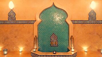 Stunning tile work adorns the archway, complemented by elegant wall-mounted fixtures and a decorative centerpiece.