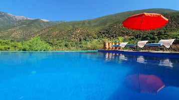 Piscine extérieure, parasols de plage, chaises longues