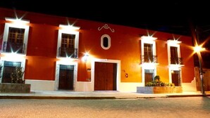A building with multiple windows and doors, illuminated by exterior lights. - Hotel Hacienda Don Cenobio (San Pablo Villa de Mitla)