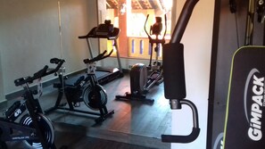 A gym with stationary bikes, a treadmill, and a rowing machine. - Hotel Hacienda Don Cenobio (San Pablo Villa de Mitla)