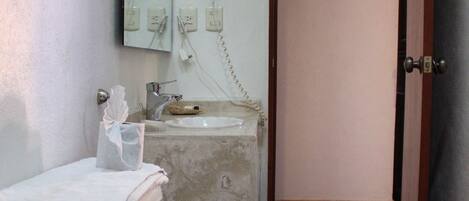 A bathroom with a toilet, sink, and mirror.