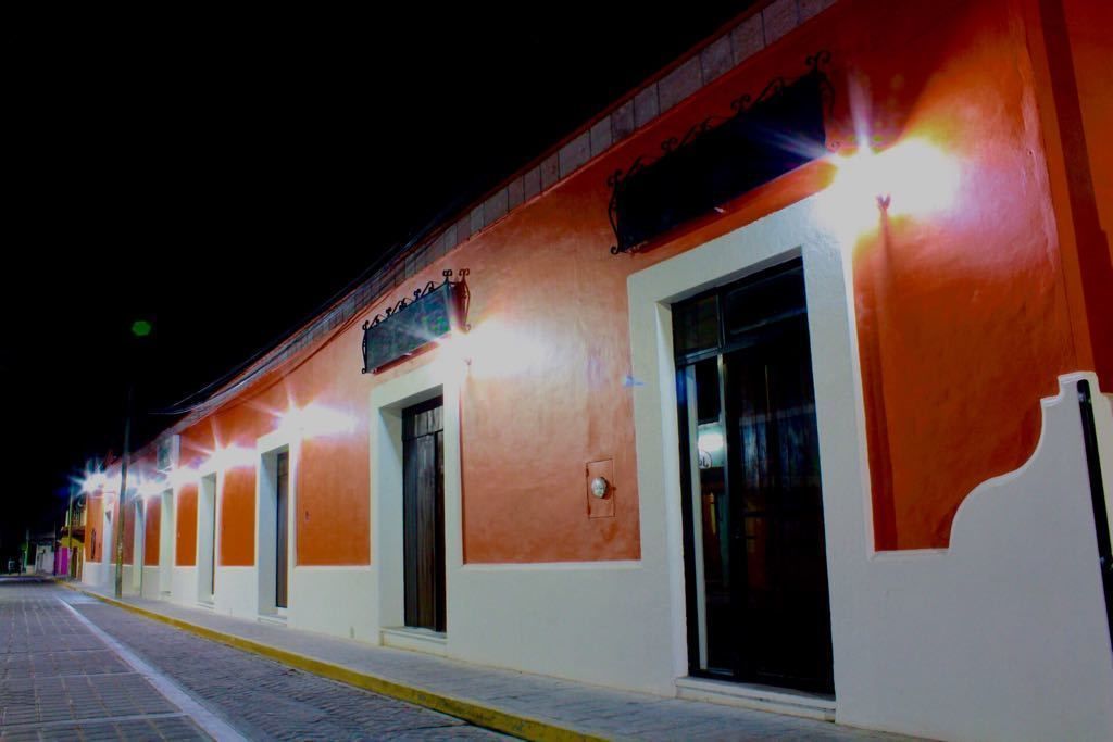 A building with multiple doors and windows, illuminated by exterior lights.