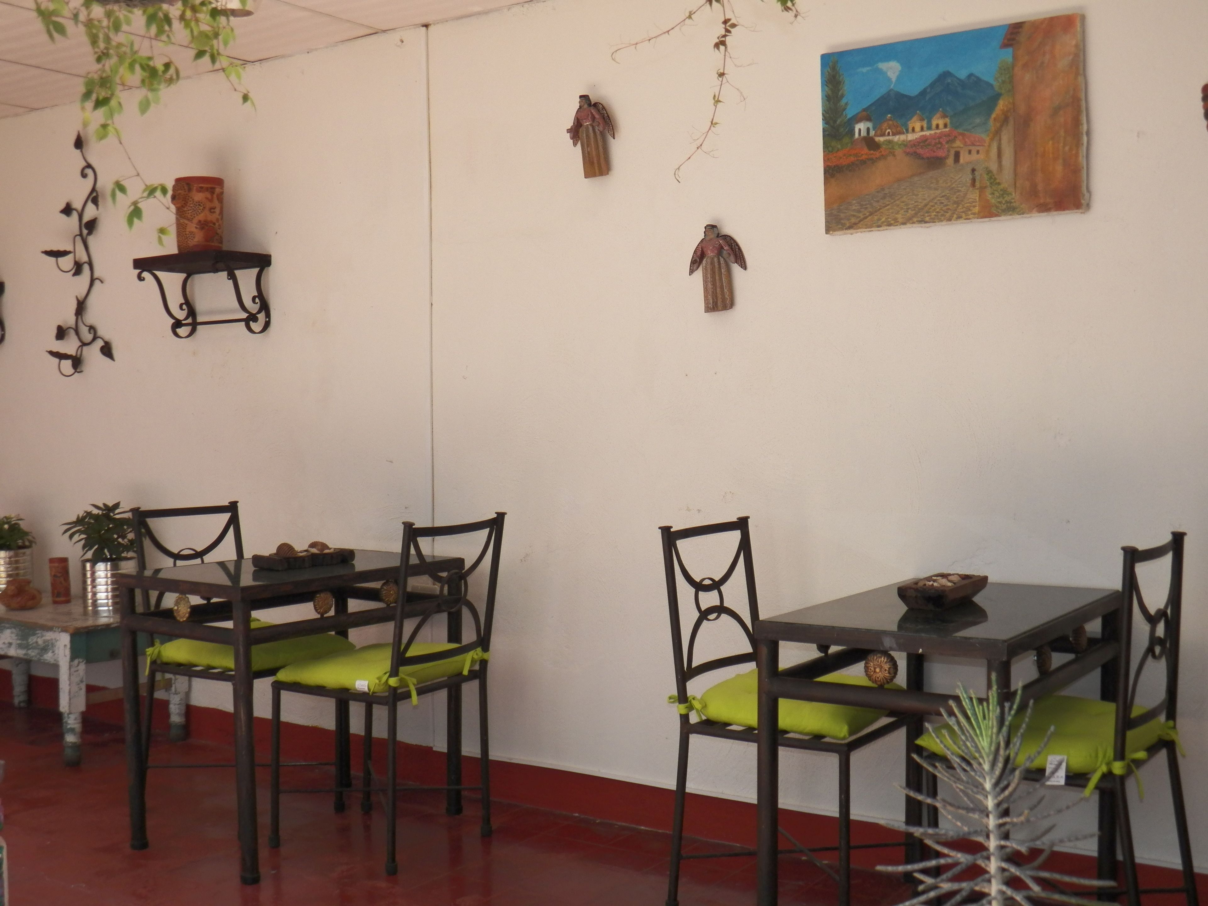 Un comedor con mesas y sillas, un cuadro en la pared y elementos decorativos.
