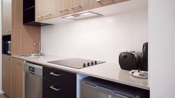 A modern kitchen with wooden cabinets, a stainless steel dishwasher, and a coffee machine.