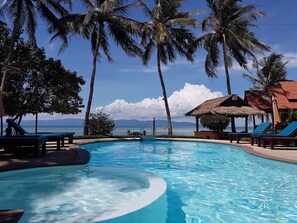 A clear blue pool with lounge chairs and palm trees, overlooking a calm sea and distant mountains. - Morning Star Resort (Ko Pha-ngan)