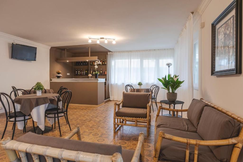 A dining area with a bar, wicker furniture, and a television mounted on the wall.