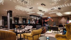 A modern lounge area with contemporary furniture, ambient lighting, and a central seating arrangement. - Motel One Berlin-Potsdamer Platz (Berlin)