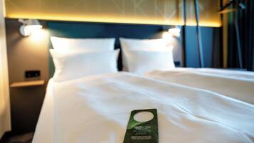 Une chambre d’hôtel avec un lit soigneusement fait, une tête de lit dotée d’un éclairage d’ambiance et une étiquette indiquant les services disponibles sur le lit.