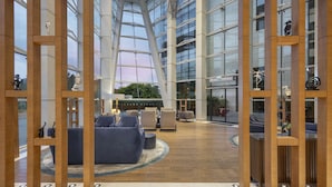 Un hall espacioso con muebles modernos, techo alto y ventanas amplias.