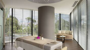Relax in a serene space with a large bed, curved seating area, and unique architectural element.