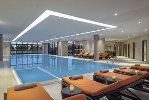 Una piscina techada, sillones reclinables de piscina