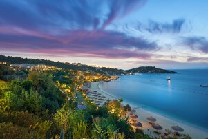 Un complejo turístico frente al mar con bungalows sobre el agua y vistas al océano.
