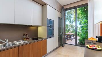 Una cocina moderna con horno empotrado, un lavamanos y una zona de comedor con mesa y sillas.