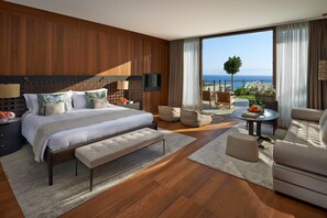 A modern hotel room with a large bed, a seating area with a table, and a balcony with a view of the sea. - Mandarin Oriental, Bodrum (Bodrum)